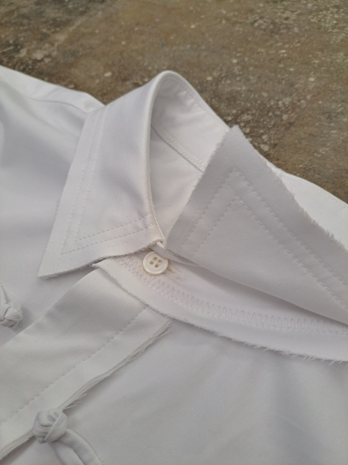 Grey garment seam, button and construction detail